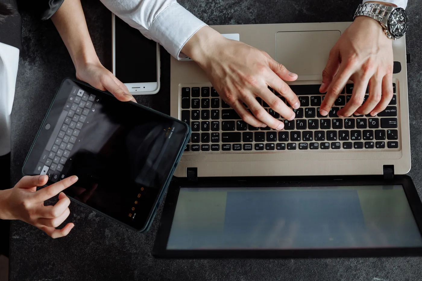 People using a laptop and tablet for digital healthcare work